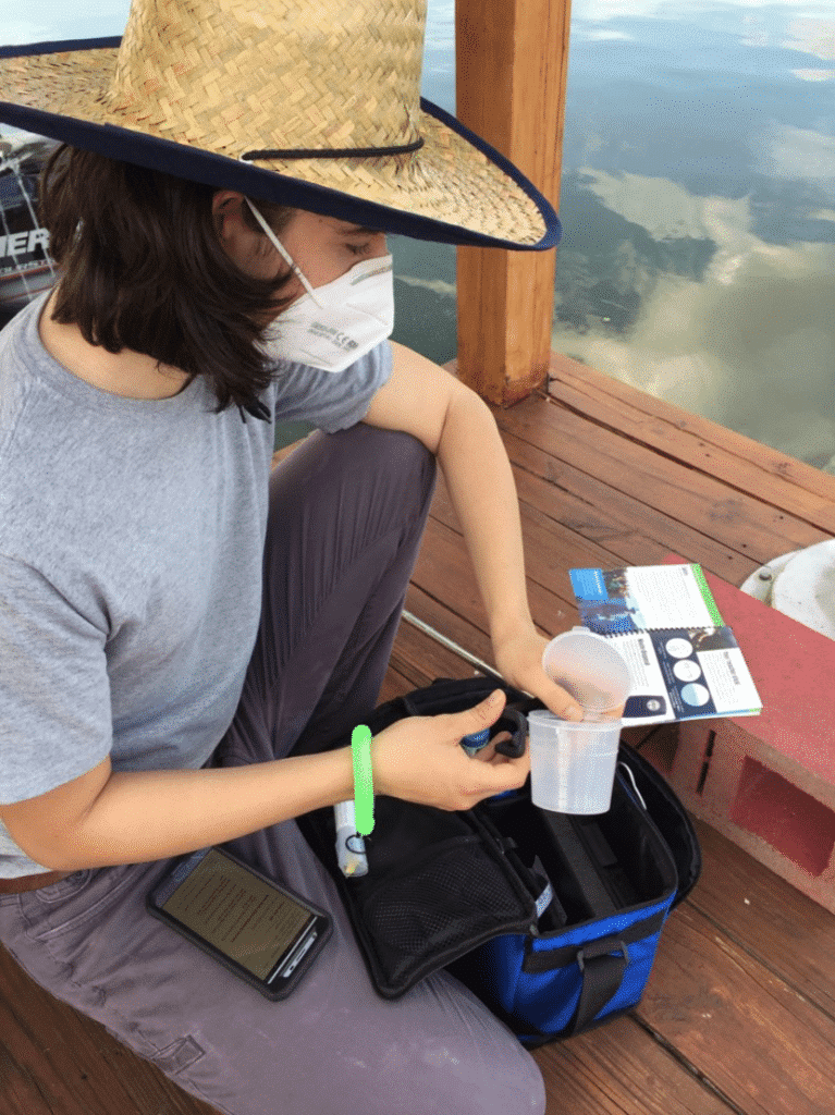 Tester in Florida attaching sample cup to a selfie stick for water testing